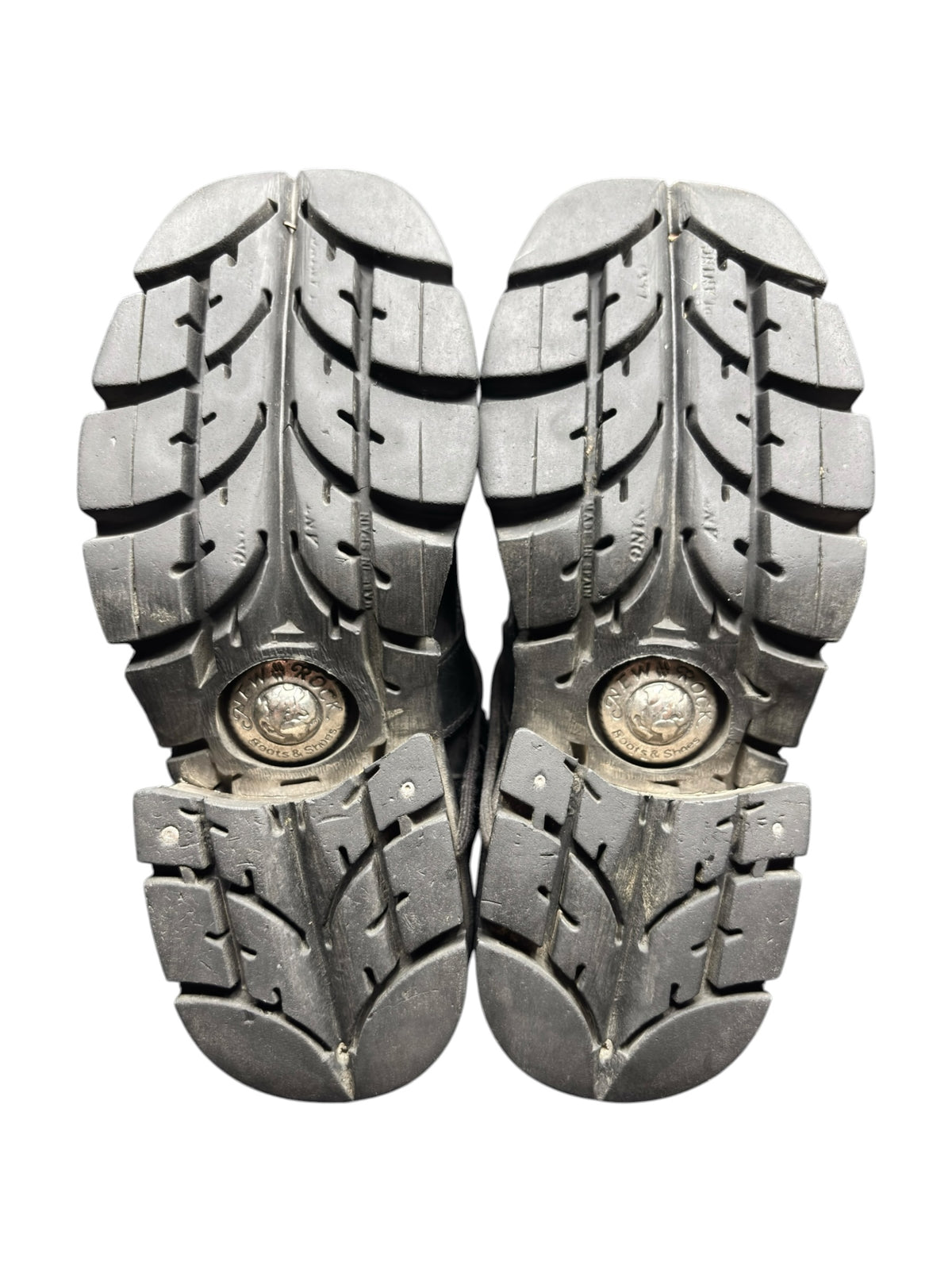 Pair of mid-calf boots showing rugged lug soles with circular logo plates