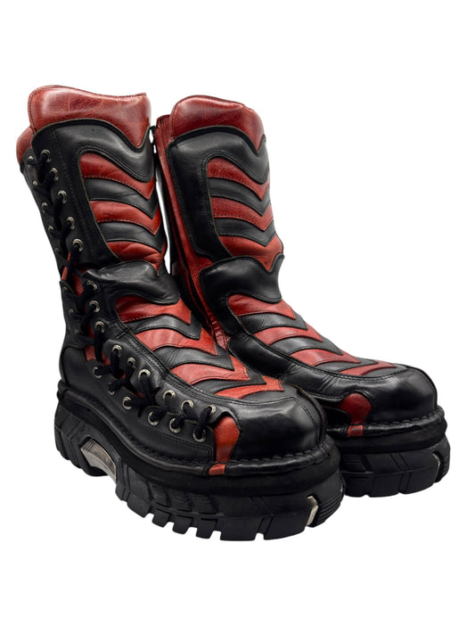 Black and red mid-calf lace-up platform boots with zigzag panels and thick lug sole.