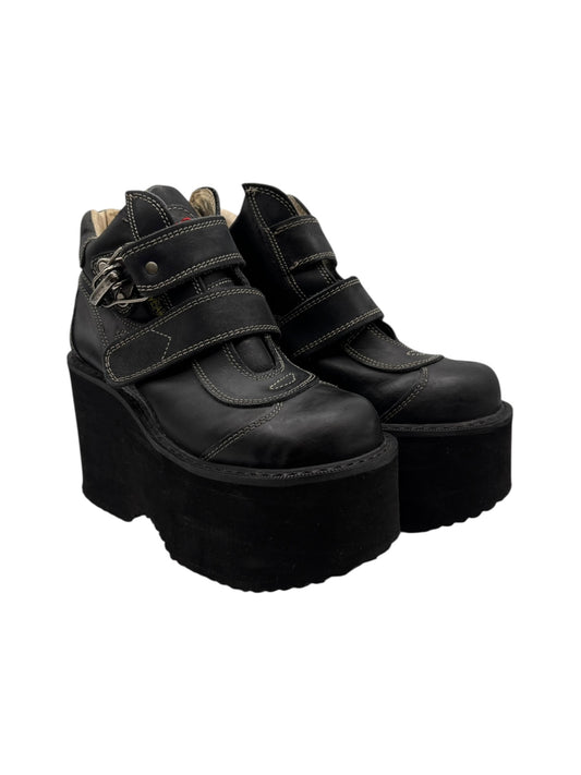 Black platform wedge boots with adjustable ankle straps and thick sole