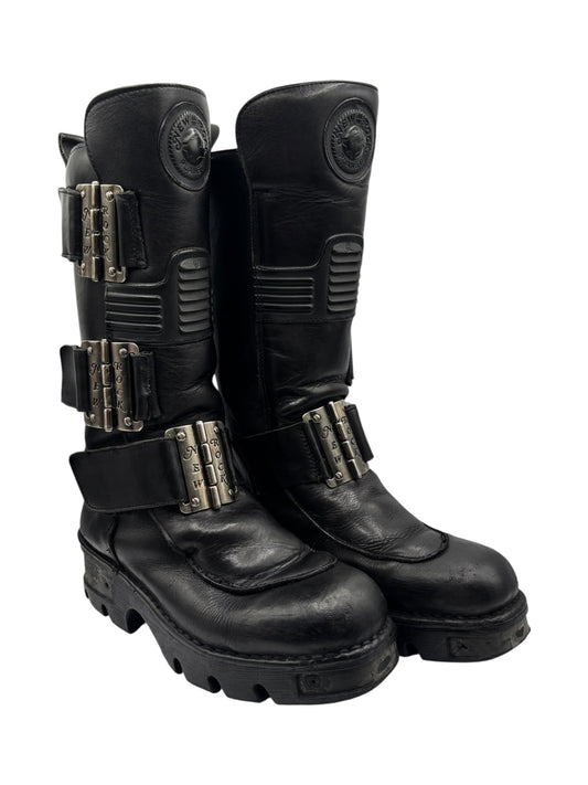 Black knee-high leather boots with multiple side buckles and chunky lug sole