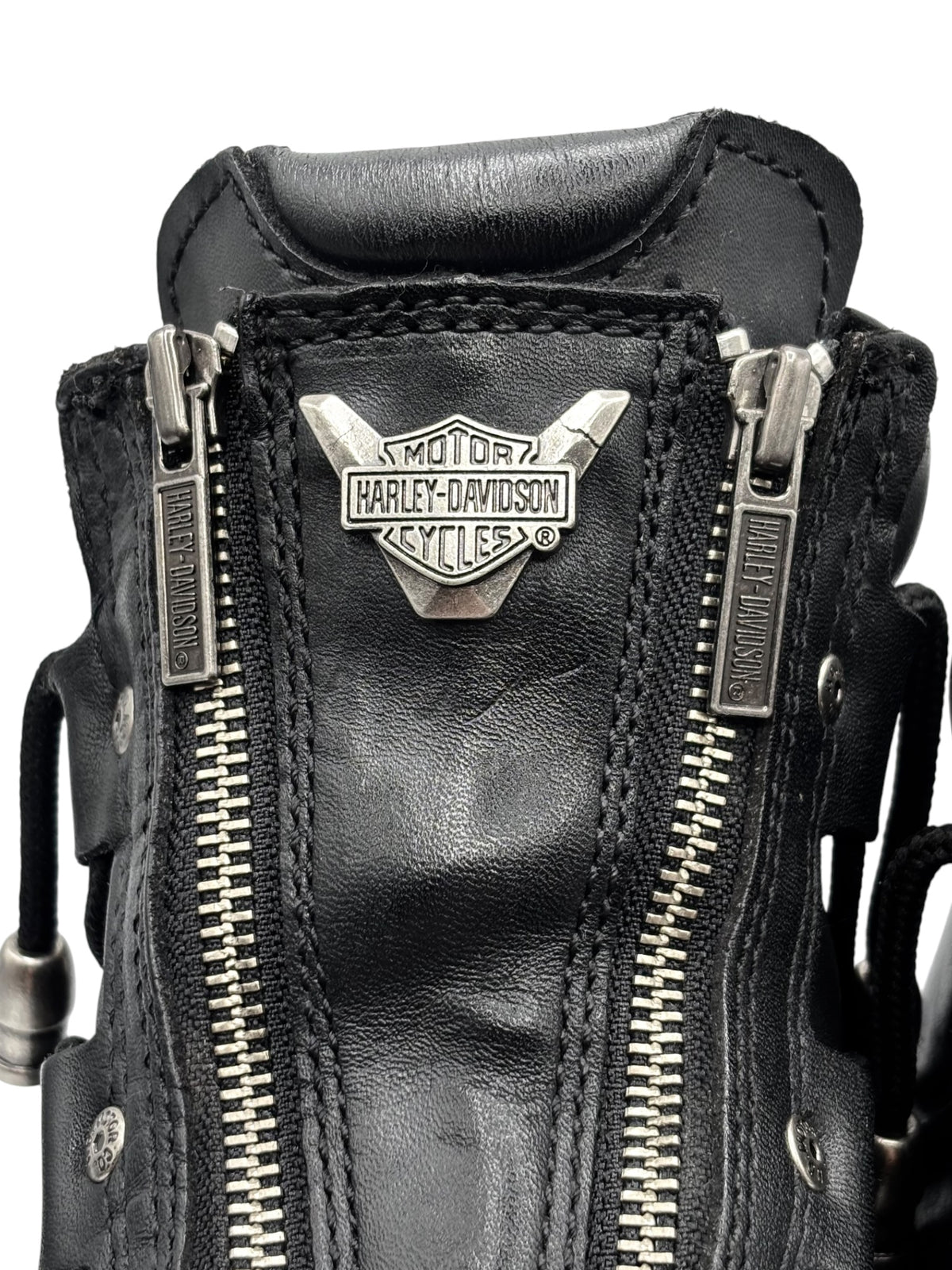 Black leather biker boots close-up with Harley-Davidson logo and double zippers