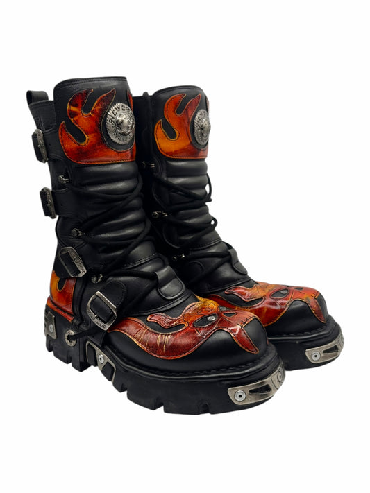 Two mid-calf black boots with orange flame graphics and chunky tread soles