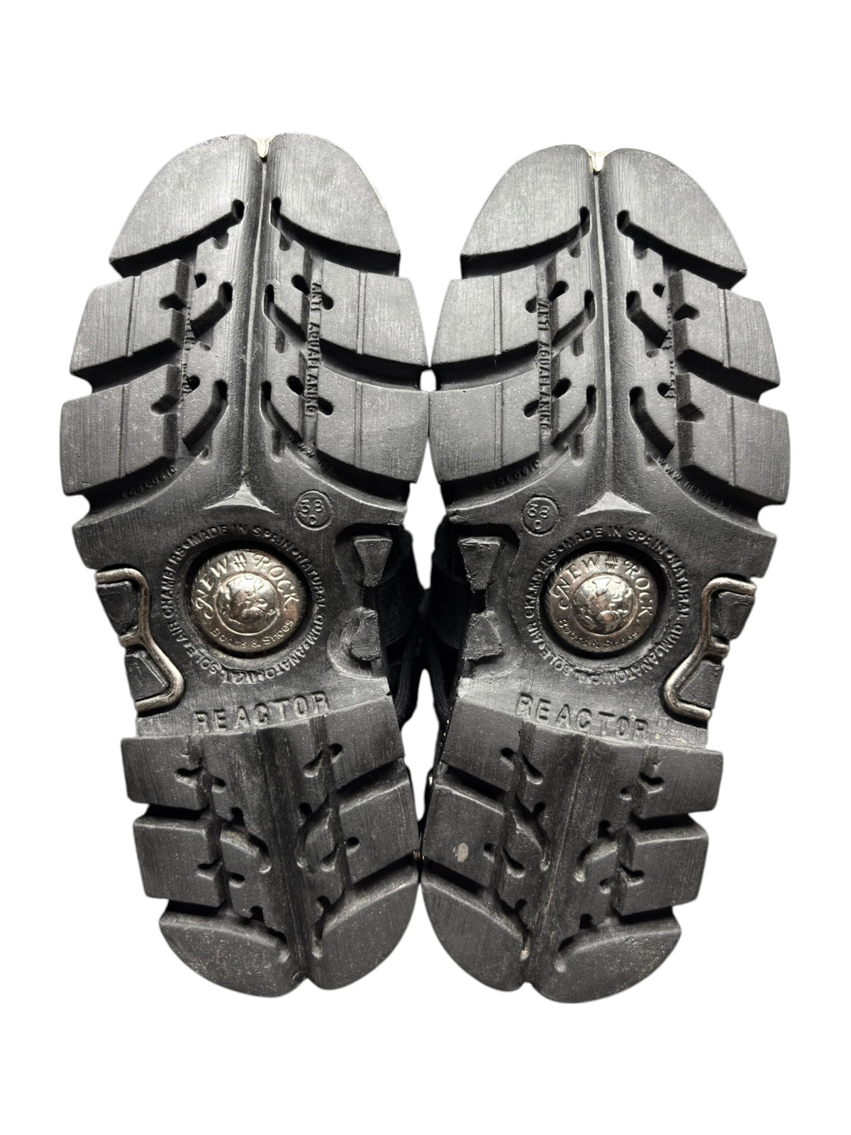 Pair of black platform boot soles, rugged tread pattern with circular “REACTOR” medallions