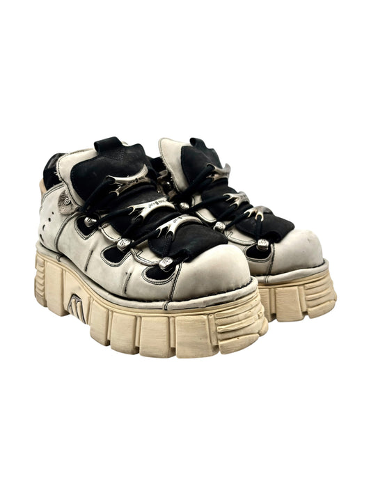 Beige and black platform lace-up boots with chunky tan lug soles and metal hardware
