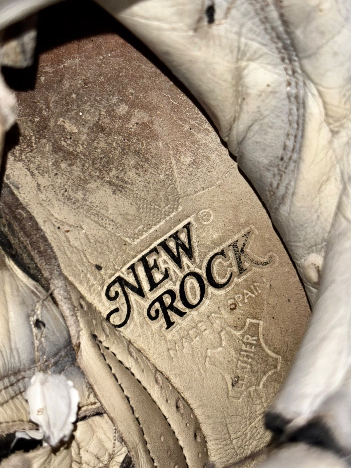 Inside heel lining of New Rock boots with worn logo patch and stitching