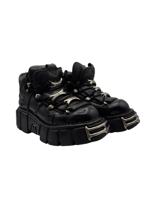 Black leather platform ankle boots with lace-up, side buckles, and chunky tread sole