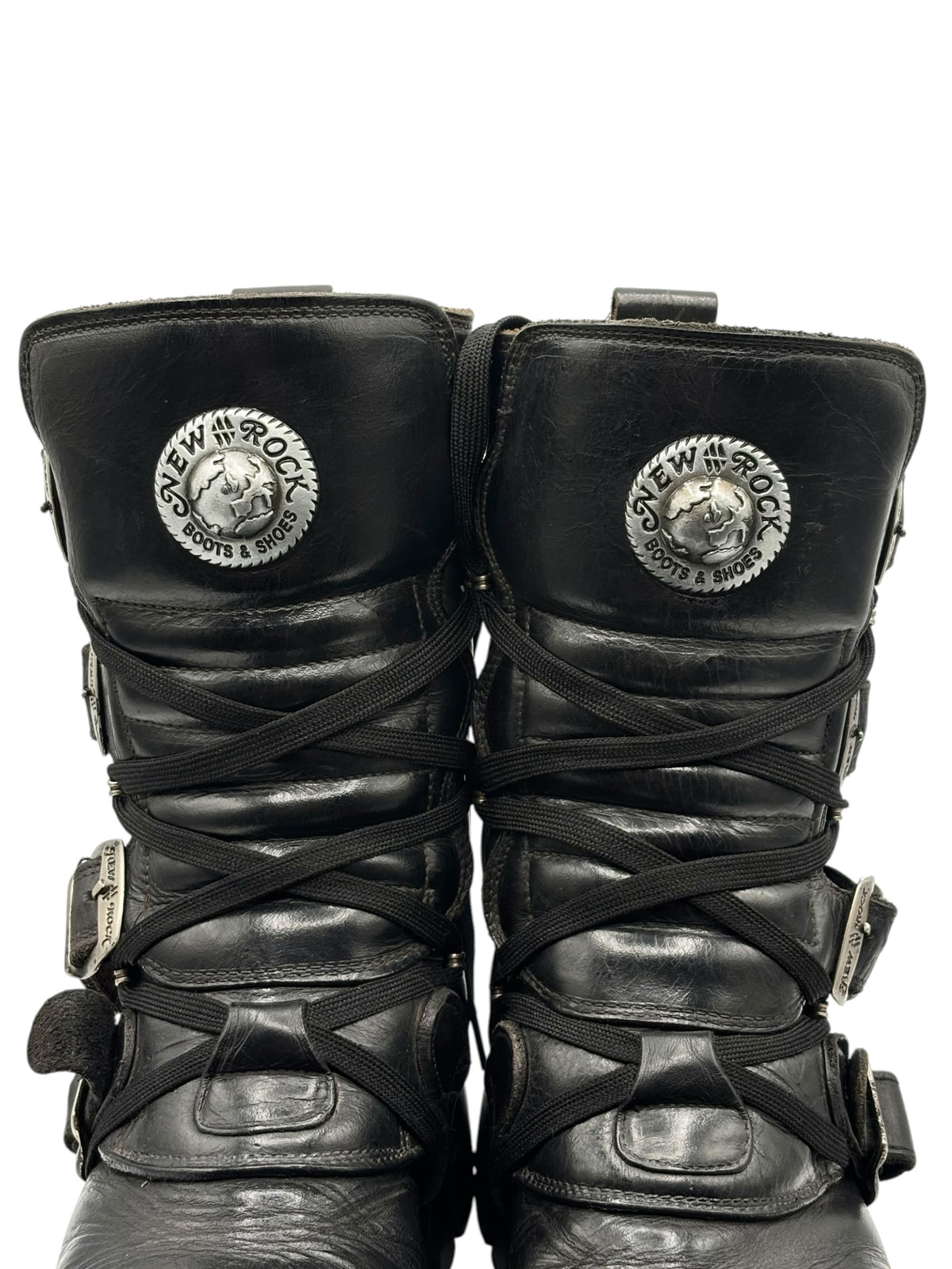 Front view of black mid-calf boots with crossed laces and circular brand patches