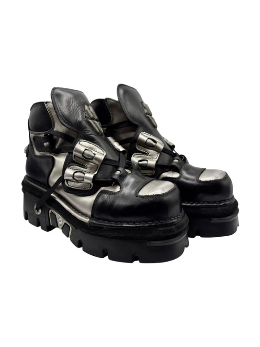 Black leather platform boots with multiple buckled straps and chunky tread sole.