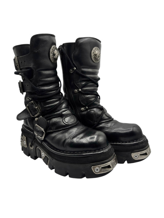 Black mid-calf leather reactor boots with side buckles, straps, and chunky sole