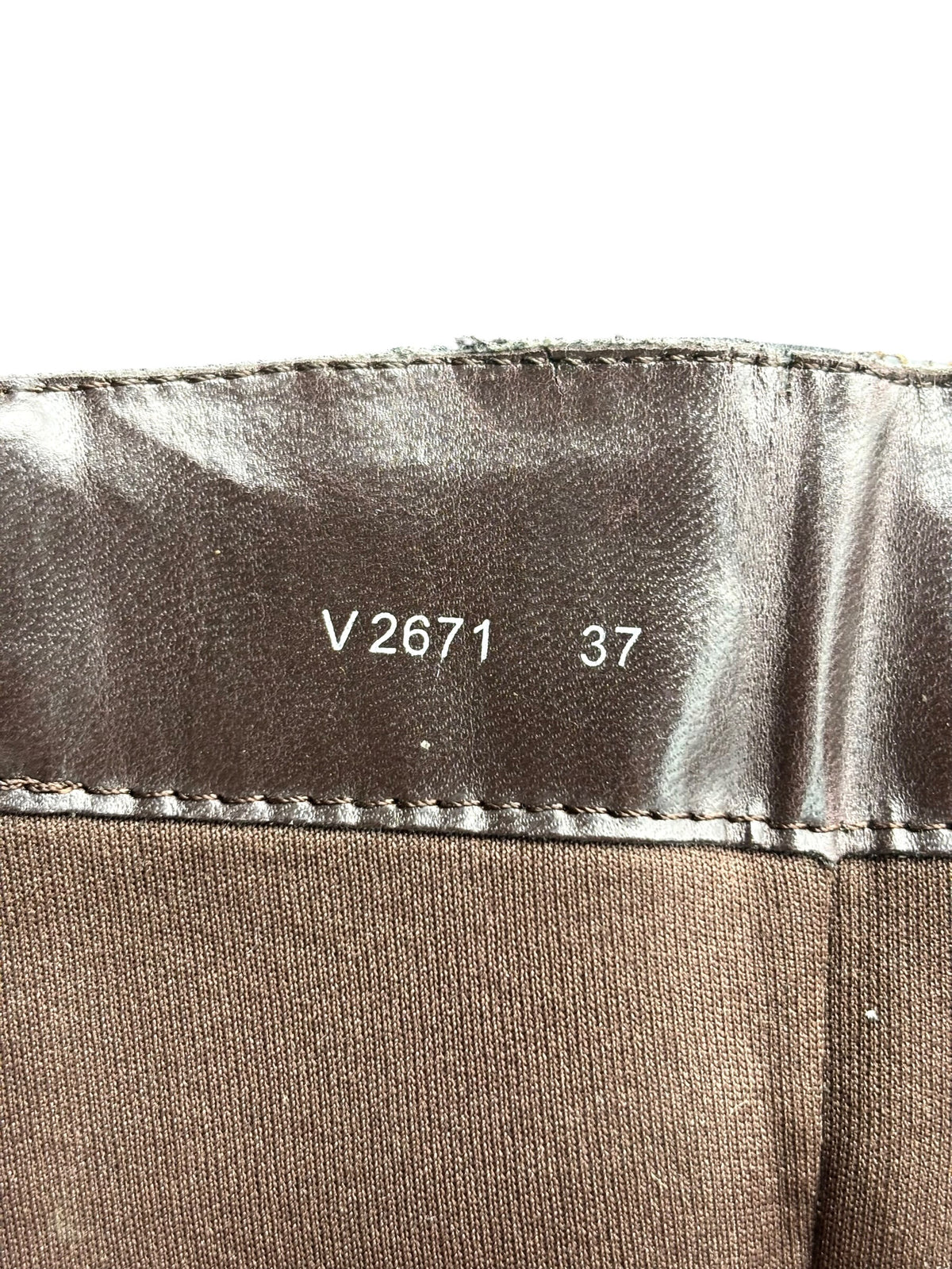 Inside cuff of knee-high boots with printed size text and stitched hem.