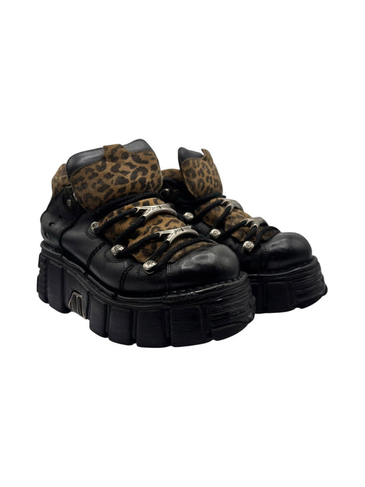 Side view of black lace-up platform boots with leopard-print tongue and collar panels