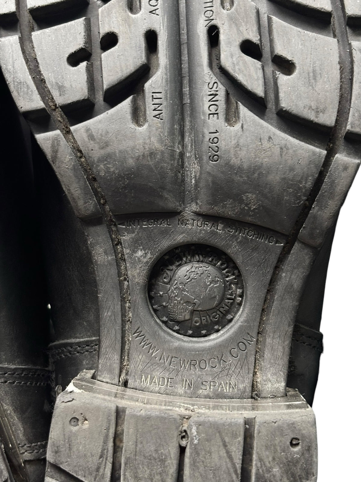 Black boot sole underside with metal stamp and tread pattern