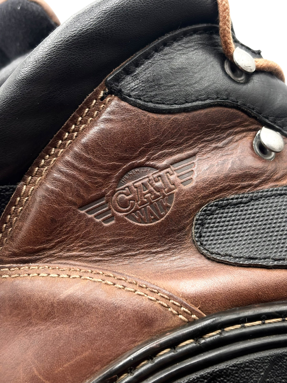 Brown leather boot side with CAT logo emblem and contrast stitched trim