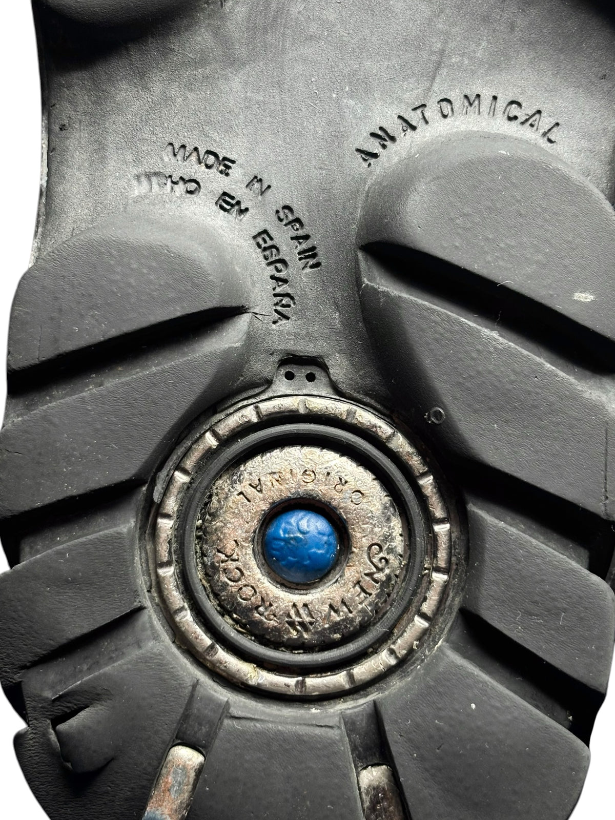 Close-up of boot outsole tread with round blue-tinted hardware detail