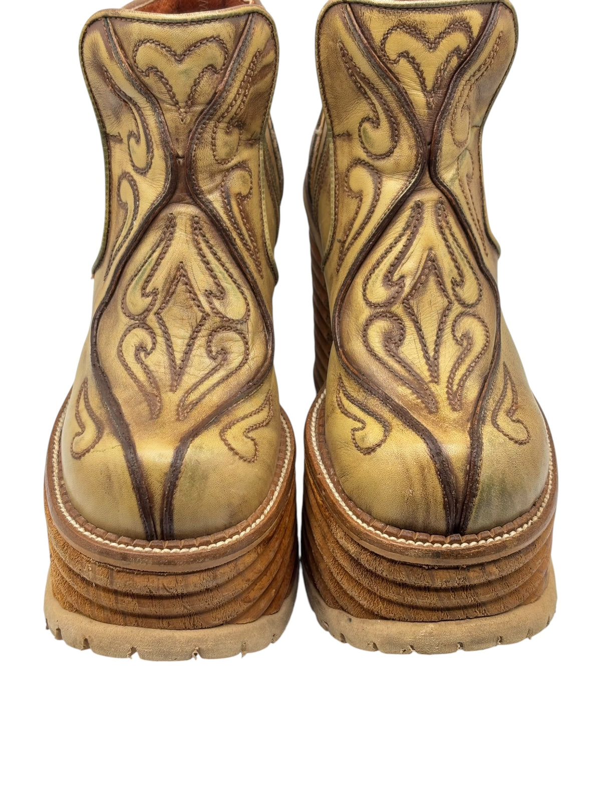Back view of khaki brown leather platform ankle boots with carved upper panels