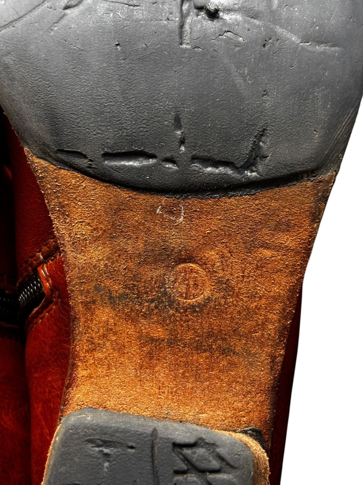 Worn leather boot sole and side panel close-up with dark rubber tread