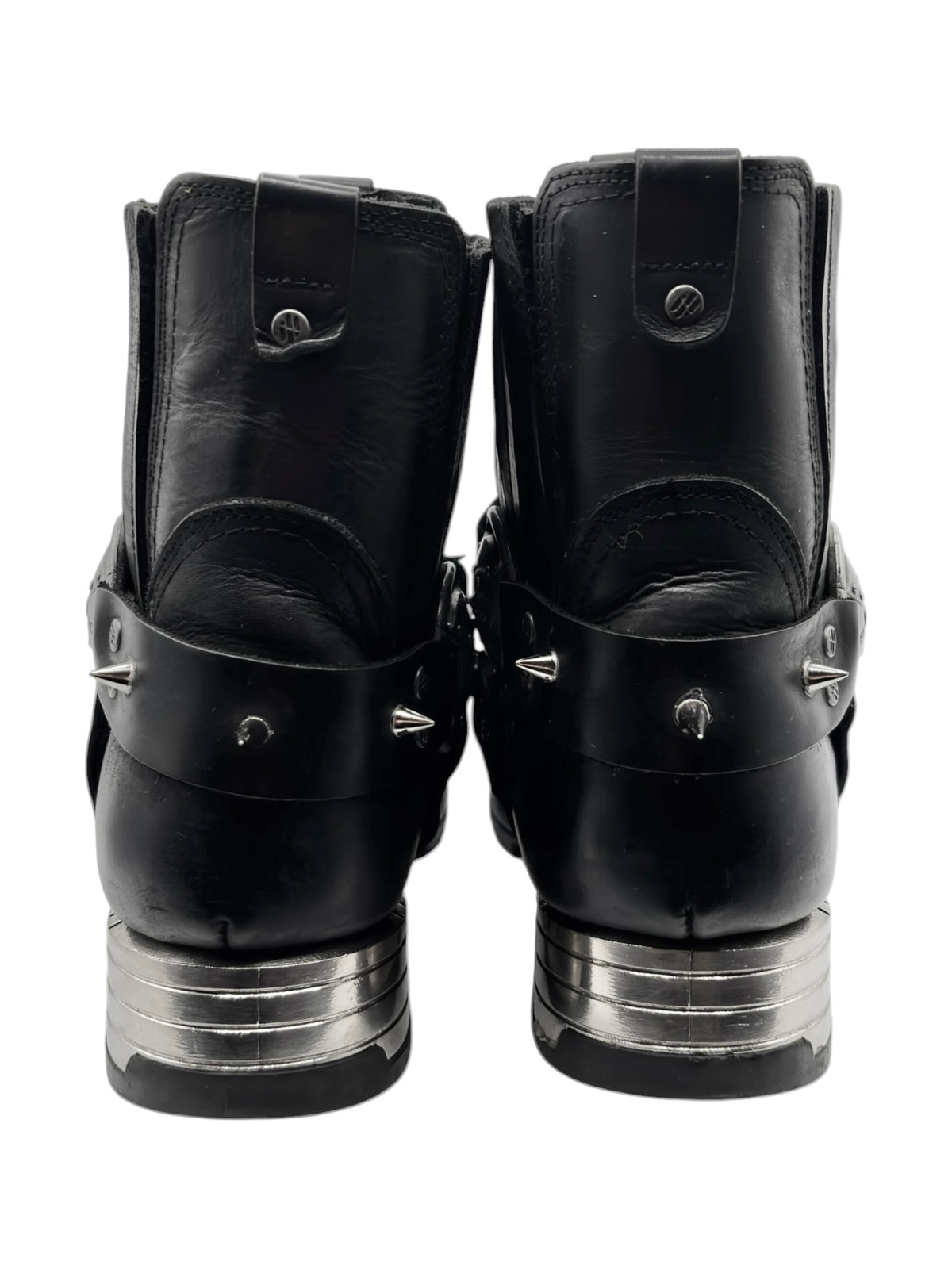 Black biker boots back view with stacked metal heel detail and straps