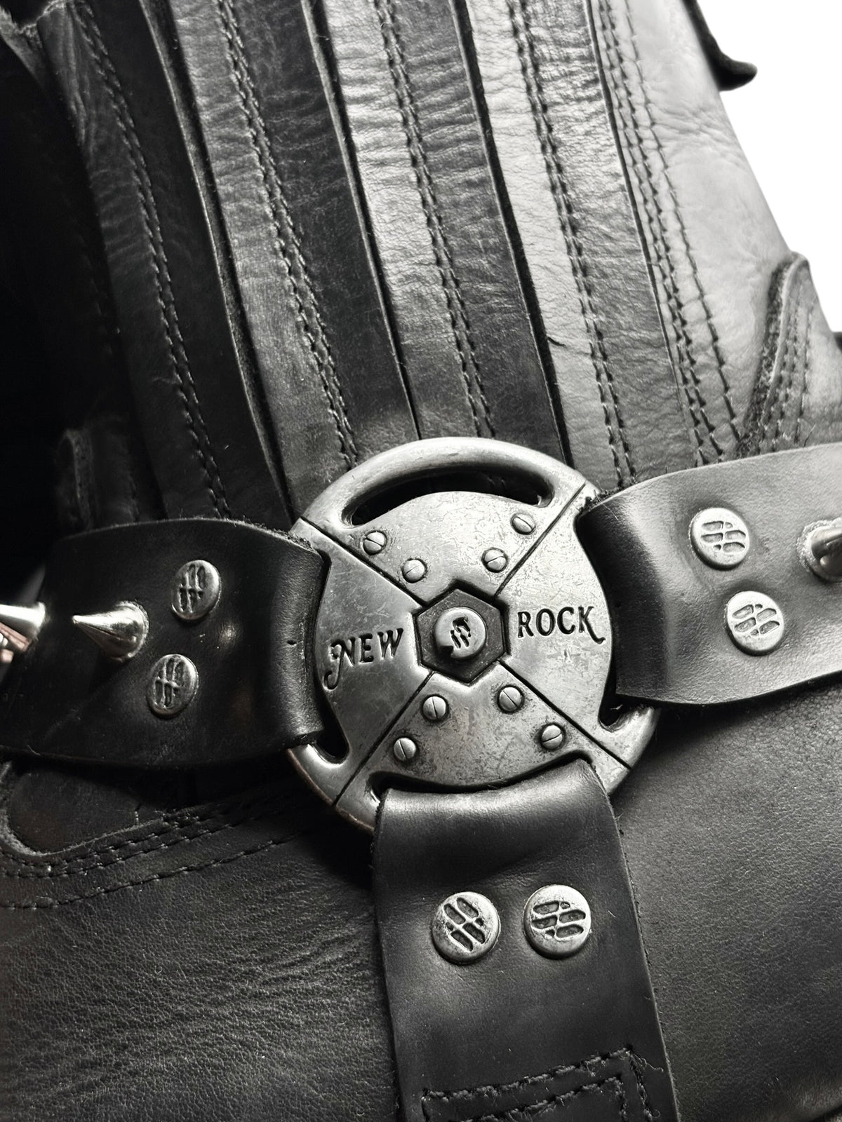 Black boot upper with metal spiked buckle featuring New Rock logo