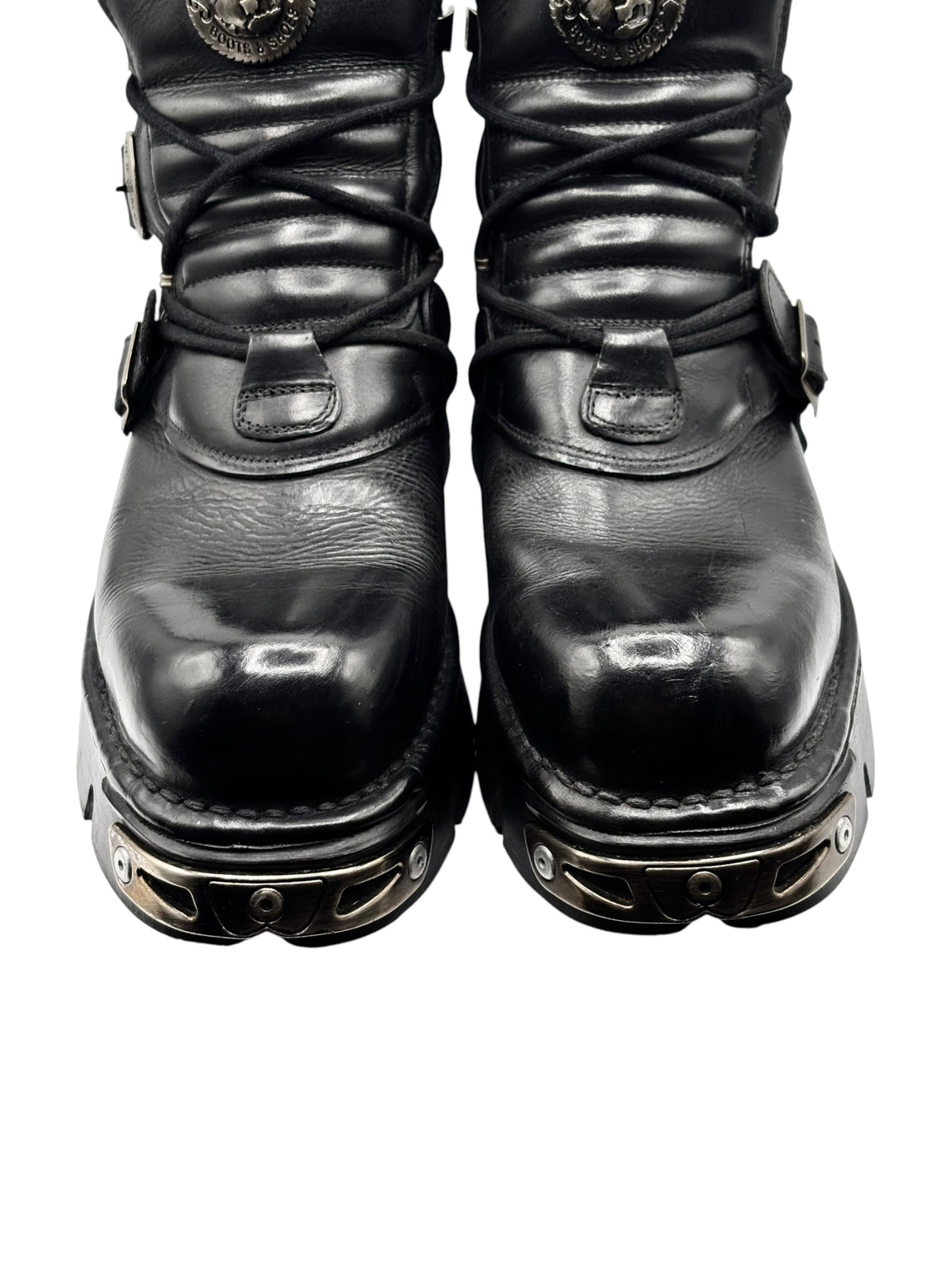 Bottom view of black ankle boots with laced uppers and metal hardware accents