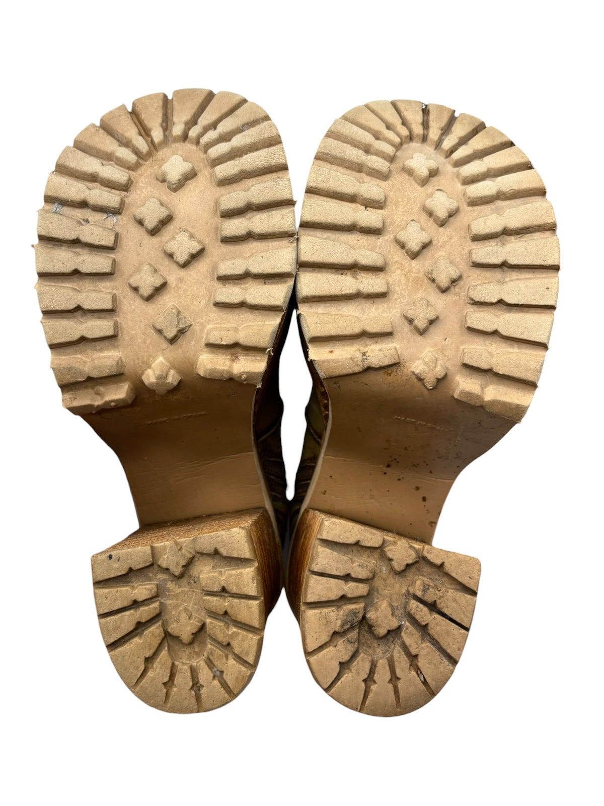 Soles of khaki brown leather platform boots with chunky tread and stacked heel