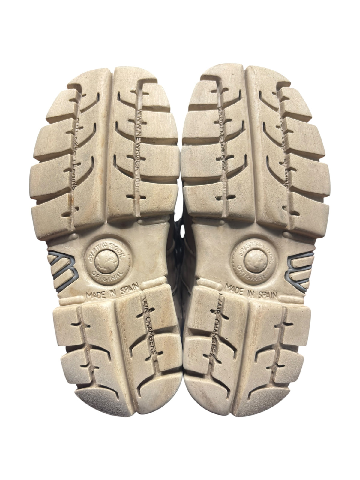 Beige boot outsoles with rugged tread and Made in Spain stamp
