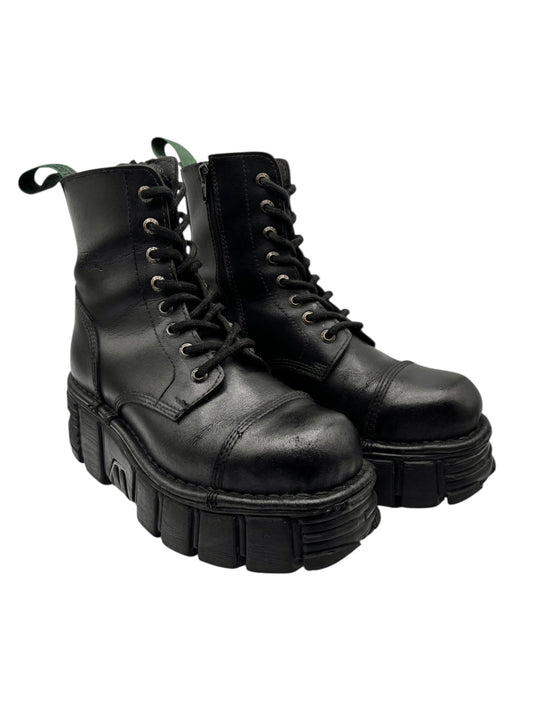 Two black leather lace-up platform boots with green pull tabs and deep tread sole