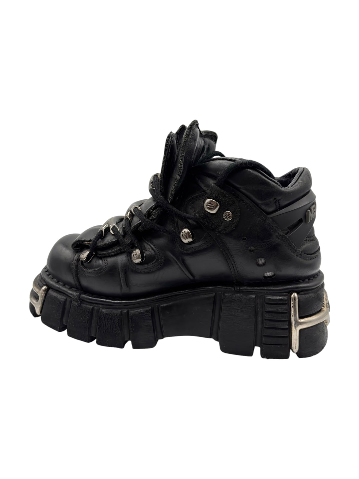 Black lace-up platform boot side view with thick tread sole and metal studs