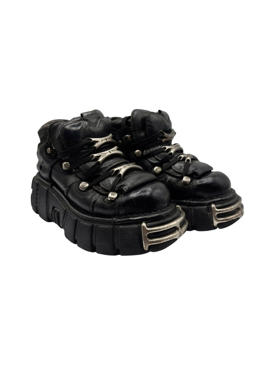Black platform boots with side profile, chunky tread sole, and silver metal trim details.