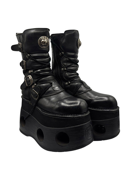 Black leather platform boots with front buckles and large circular sole cutouts