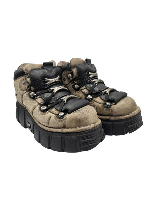 Two grey and tan lace-up platform boots with black laces and chunky tread