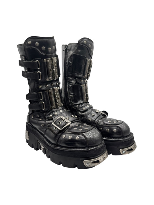 Black leather platform boots with metal buckles, studded straps, and chunky sole.