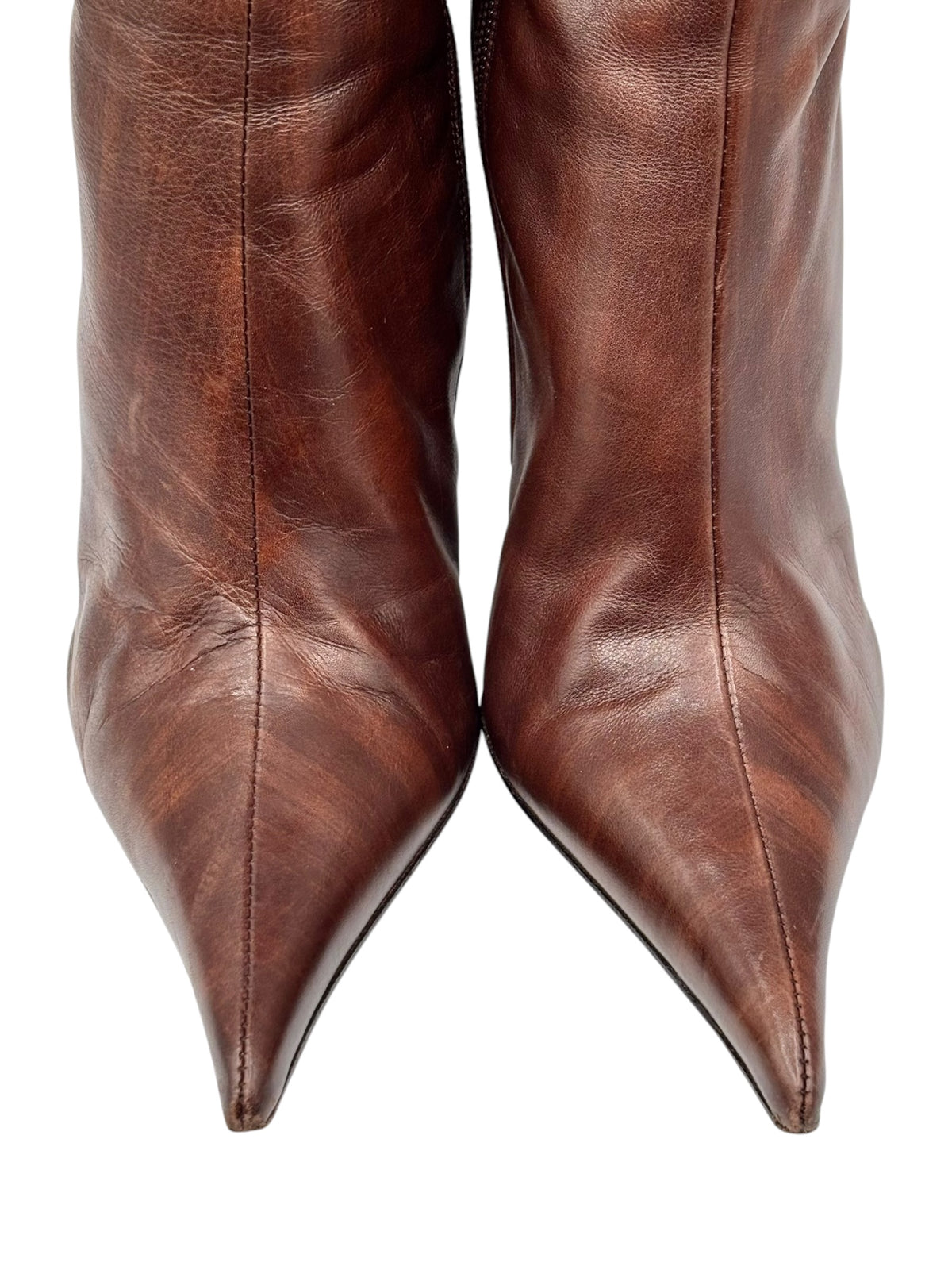 Dark brown leather knee-high boots, close-up of pointed toe and smooth shaft