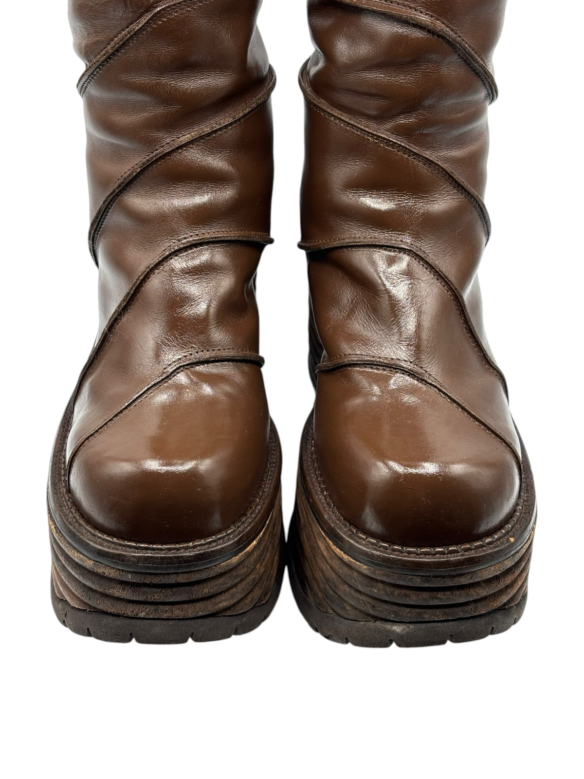 Brown knee-high platform boots with stacked sole and stitched side panels