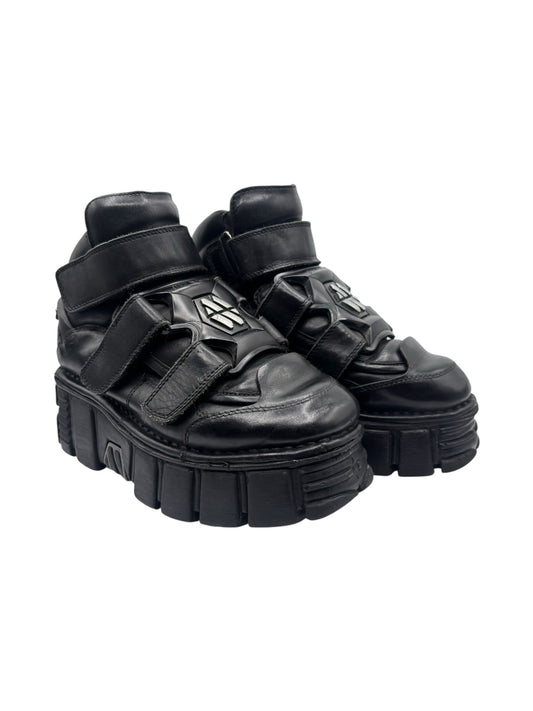 Black platform boots side view with strap buckles and thick tread outsole