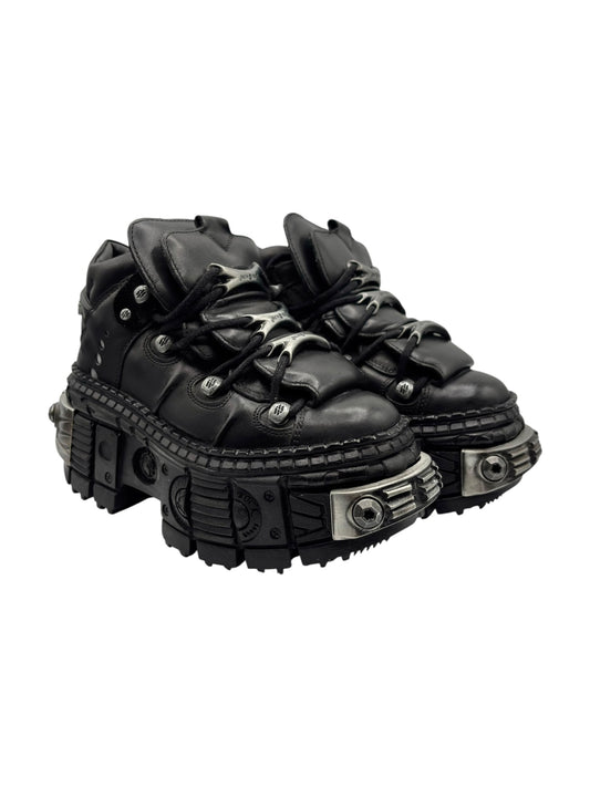 Black platform boots side view with lace-up front and studded outsole