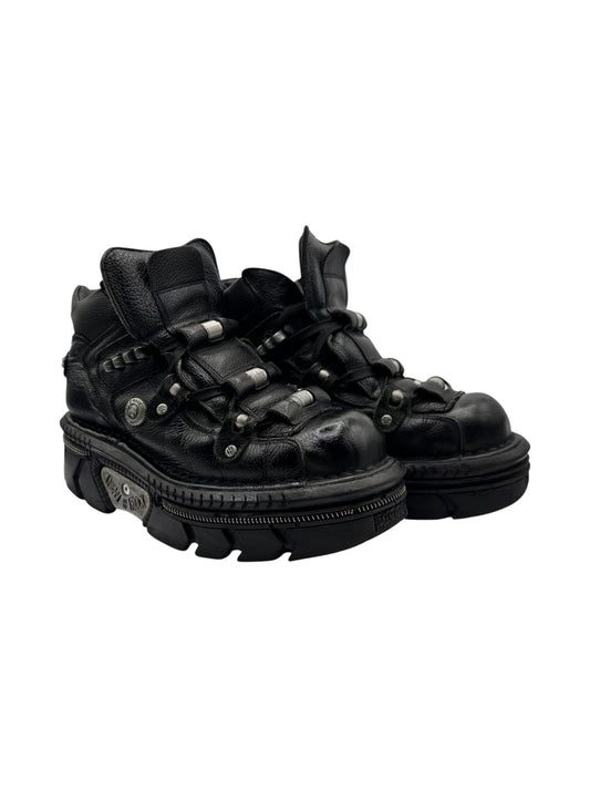 Black leather platform boots with lace-up design and metal eyelets, chunky sole