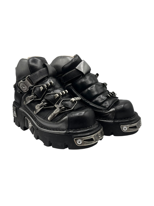 Black chunky platform leather boots with buckles, straps, and metal eyelet details