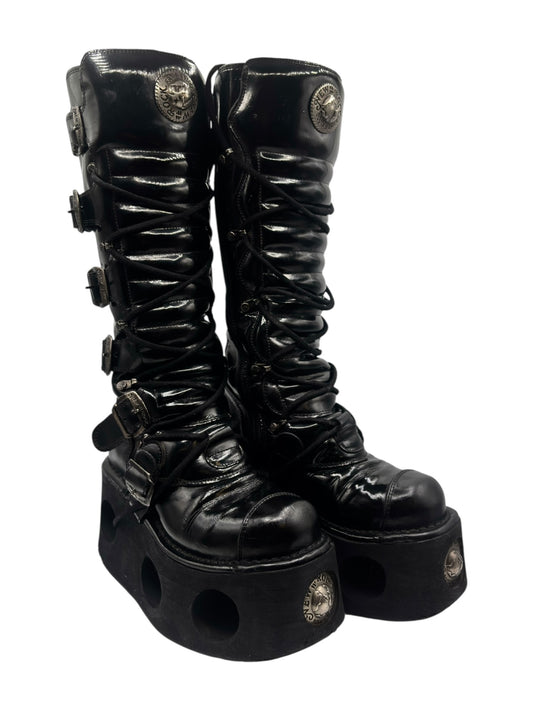 Black knee-high leather lace-up boots with chunky platform sole and side straps