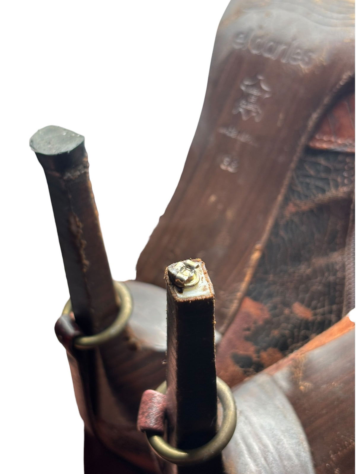 Knee-high boot shaft close-up with brass rings and patchwork leather panels.