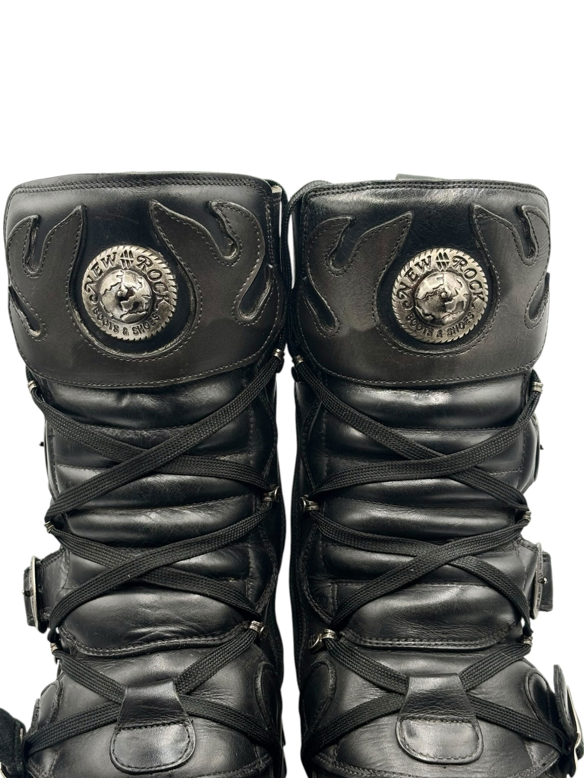 Black New Rock Reactor boots front view with circular emblem patches and crisscross laces.