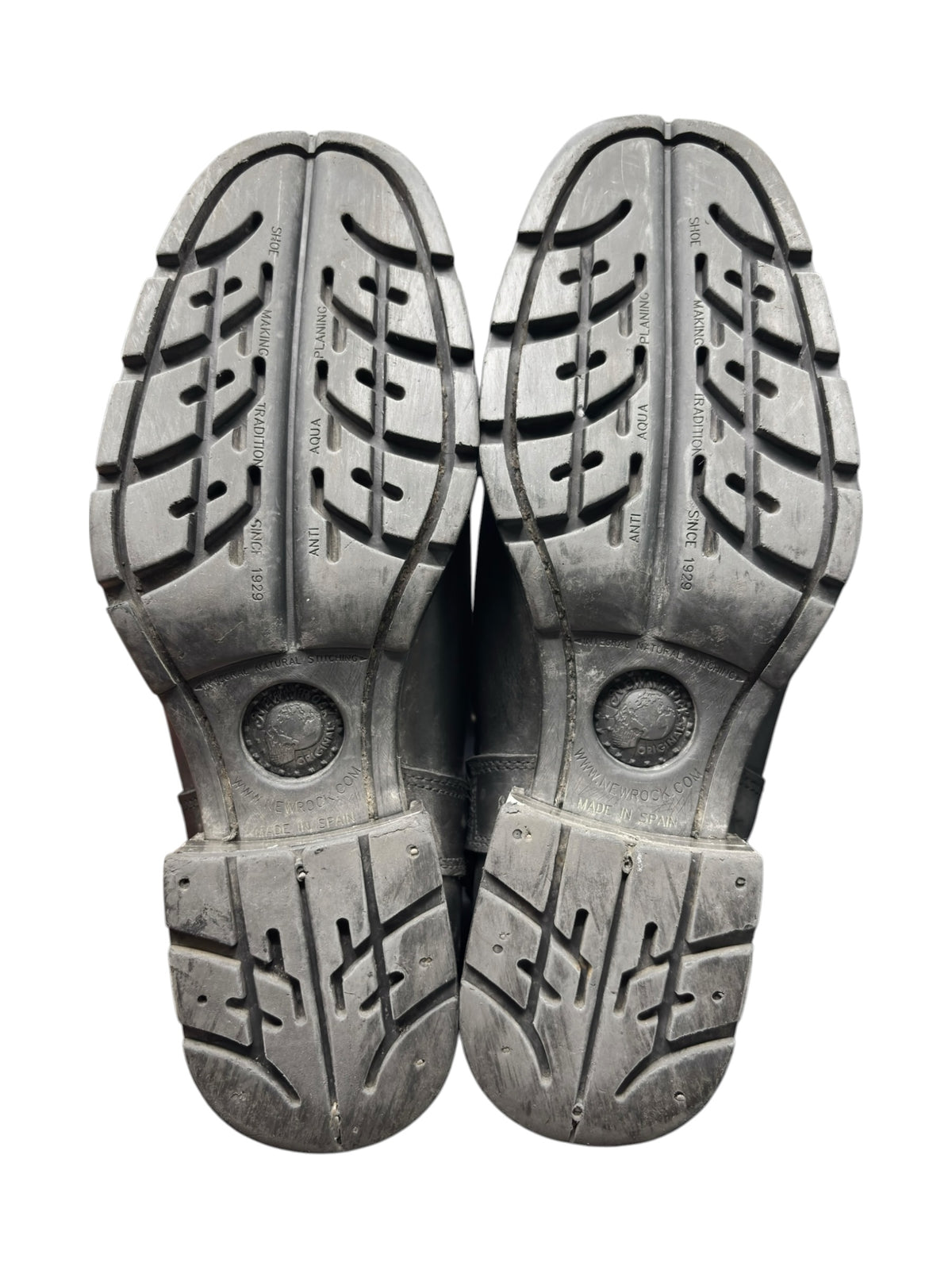 Pair of black boot soles with molded tread and circular traction details