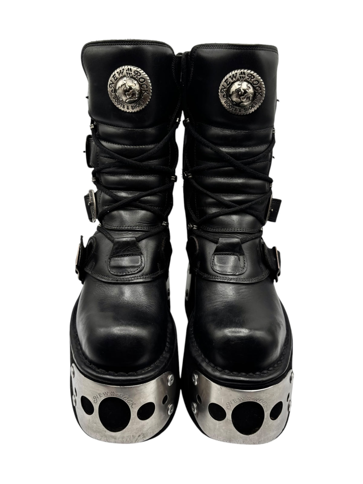 Black platform boots with round embossed badges on the ankle and silver sole plates