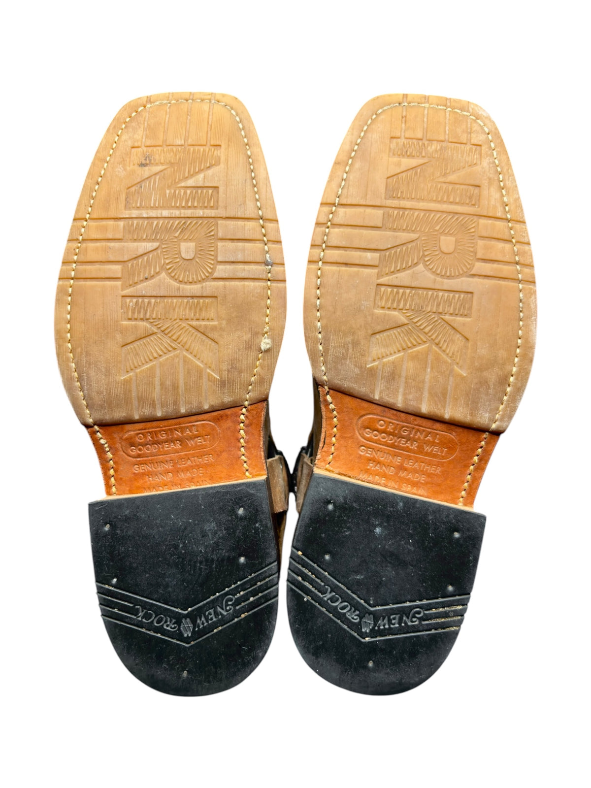 Beige cowboy boot outsoles with tread and brand markings on heel