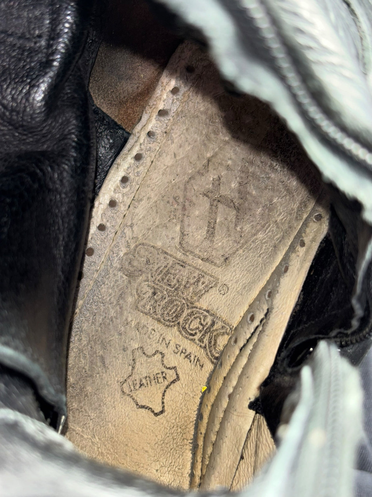Black leather boot interior lining with stitched brand logo and size label