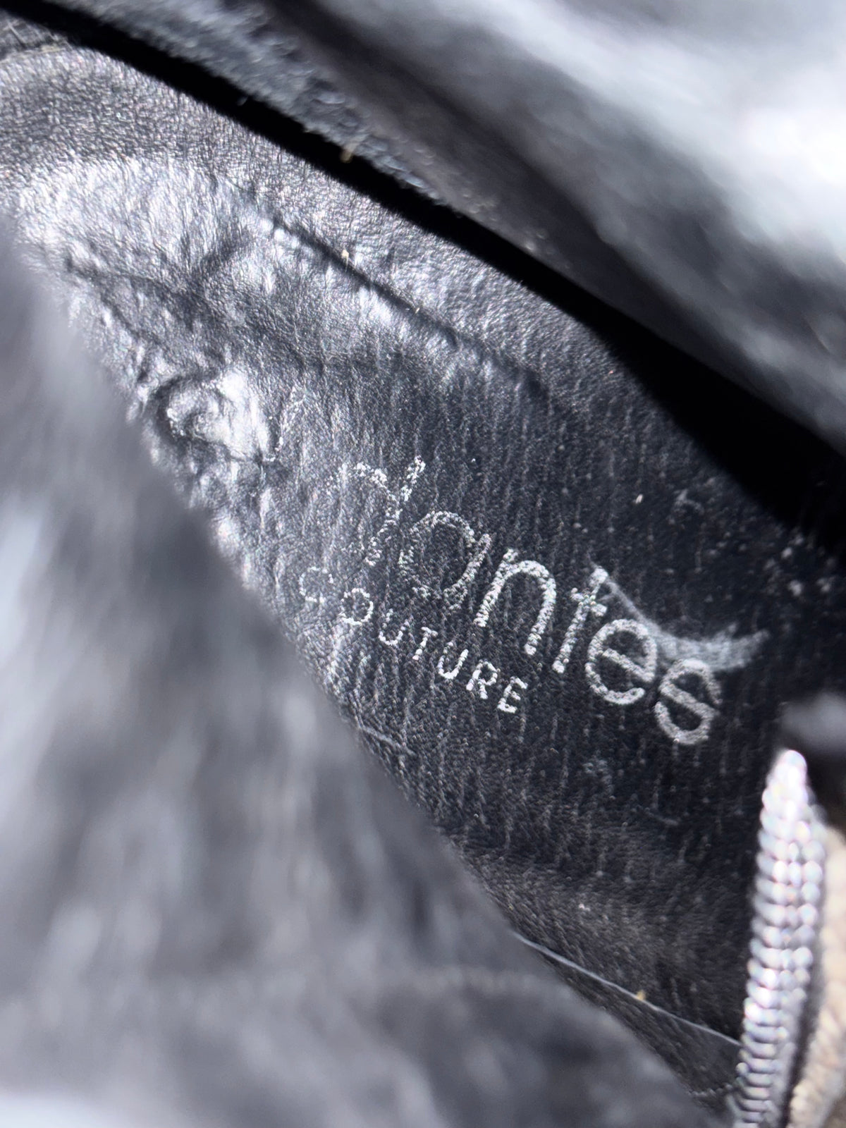 Close-up of black leather boot lining with embossed text