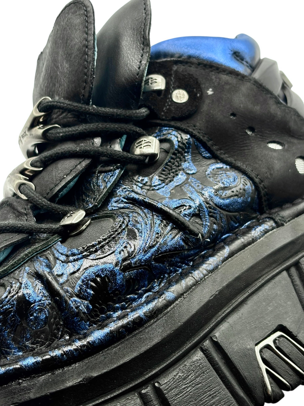 Close-up of blue patterned boot upper with black laces and metal eyelets