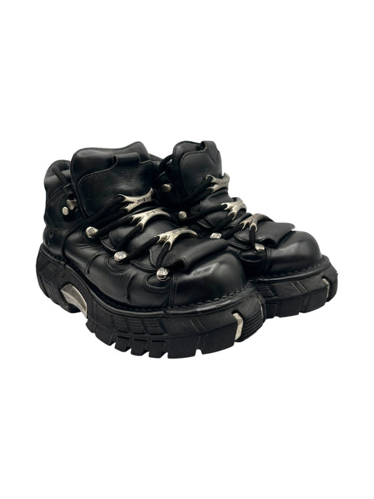 Side view of black lace-up platform boots with metal eyelets and thick tread sole