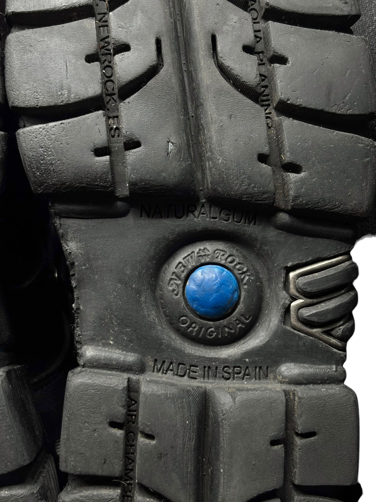Close-up of black boot outsole tread with blue emblem and “MADE IN SPAIN”