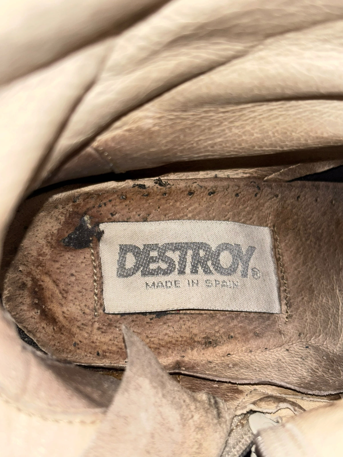 Tan knee-high boots with “DESTROY” label inside collar, distressed vintage lining.