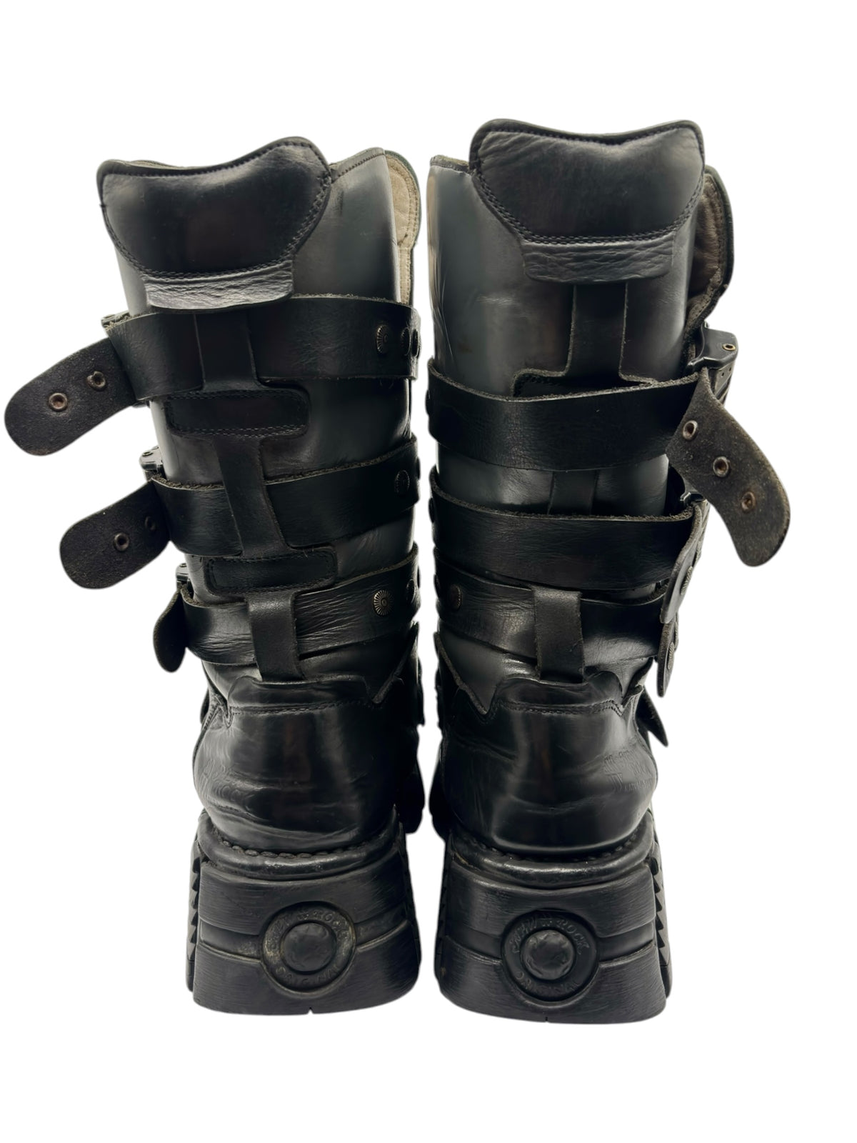 Back view of black studded strap boots showing padded heel and thick outsole tread